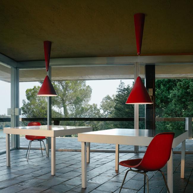 Designed by lighting design legend Achille Castiglioni for Flos, Diabolo suspension lights hang over a pair of tables in an open office space.