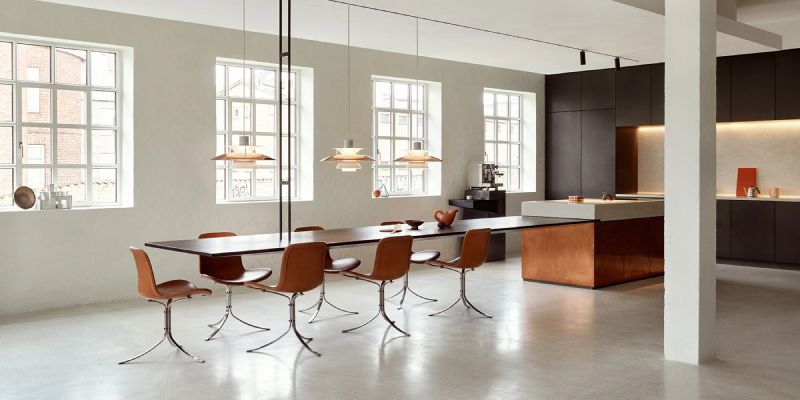 A line of PH 5 pendant lights over a long office breakroom table.