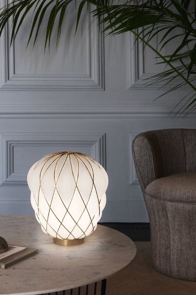 Pinecone table light from Foscarini, designed by Paola Navone, illuminating a sitting area in a lobby.