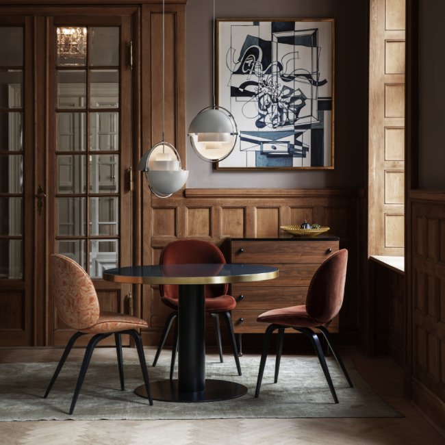 A refined yet comfortable dining nook in a wood-panelled apartment, with a duo of Multi-Lite pendant lights in white suspended above the table.