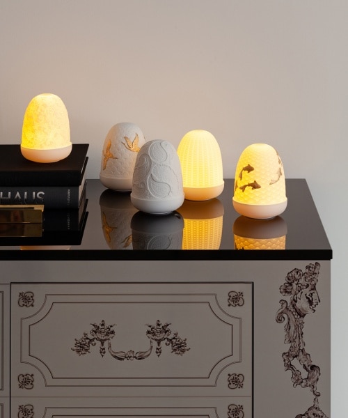 A collection of the available Dome portable table lights from Lladro on a low dresser.