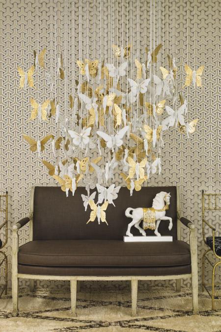 Niagara chandelier with golden lustre from Lladro hangs above a loveseat in this luxurious shot.