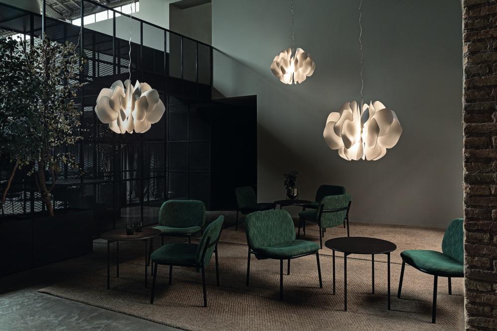 A trio of Nightbloom pendants illuminate a dramatic hotel sitting area.