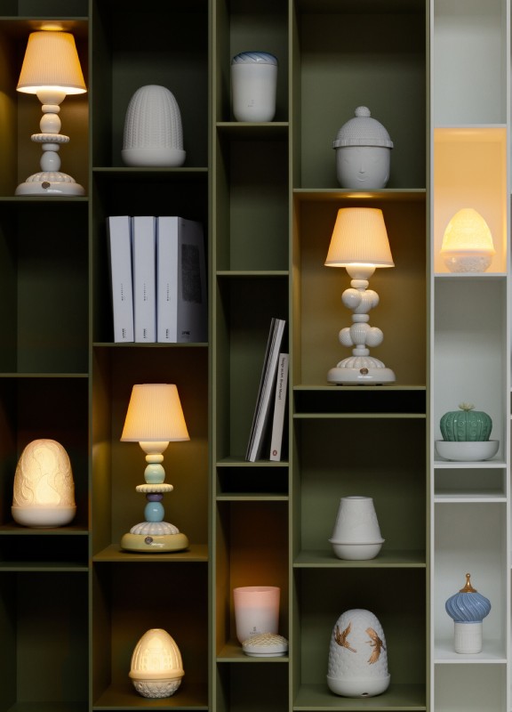 A selection of Lladro table lamps arranged in a bookshelf.