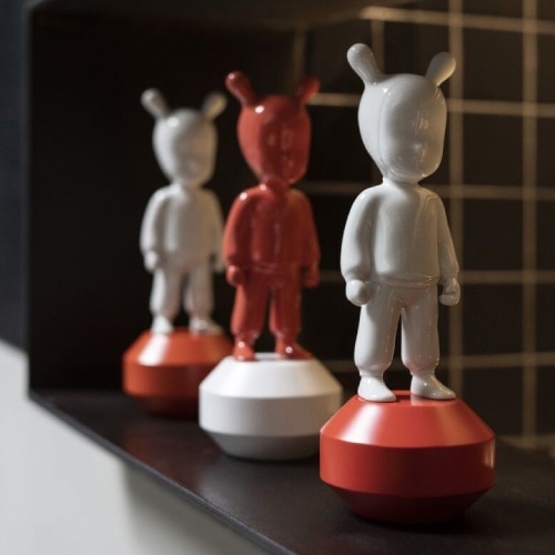 A line of Lladró's The Guest Small figurines in white and red.