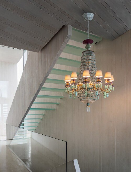 A multicolour installation of Lladro's Winter Palace chandelier in contemporary architectural stairway.