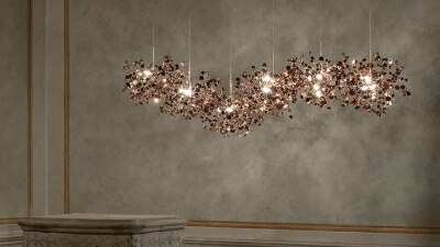 Terzani's Argent 6 Element linear suspension light in the rose gold finish hangs in a classically-decorated set.