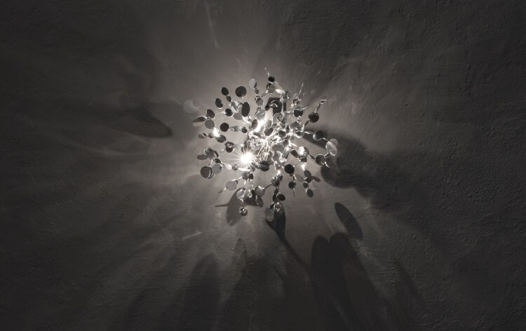 Dodo Arslan's new Argent wall sconce casts its intricate shadow across a rough-finished wall.