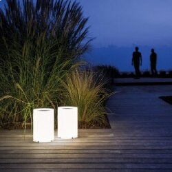 Lenta outdoor floor light from Davide Groppi illuminates a wooden pool deck as twilight fades into darkness.