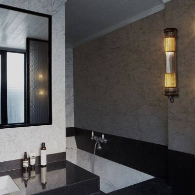 In the Tube 100-500 outdoor wall and suspension light lights a luxurious contemporary bathroom.