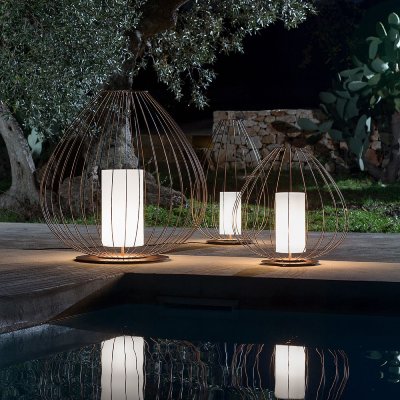 A selection of Cell outdoor floor lights sitting at the side of an outdoor pool by night.