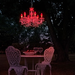 Drylight S6 outdoor suspension light offers a passionate vermillion glow to an elegant patio table set for two.