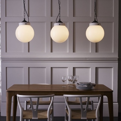 A linear cluster of Hampton outdoor pendant lights bring an elegantly rustic charm to an indoor dining application.