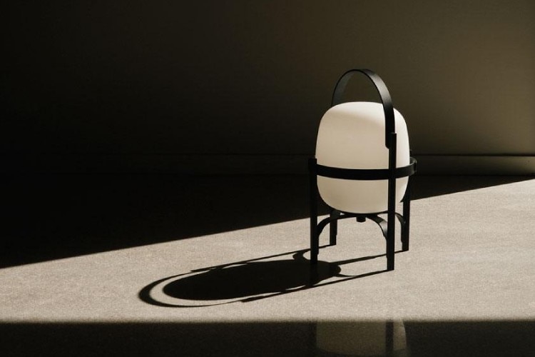 Cestita Alubat portable outdoor table light displays its beauty in a dramatic noir-esque slash of light.