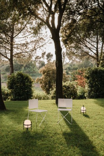 A pair of Cestita Alubat outdoor table lamps decorate a warm summer scene.