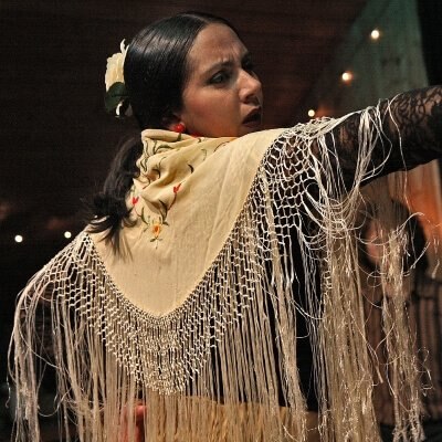 A flamenco dancer, mid-dance, wears the traditional manton de manila.