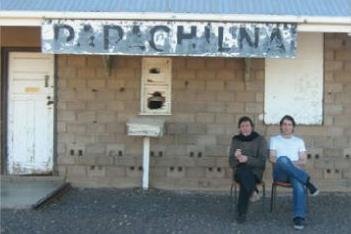 Roman Riera and Alfredo Valero sit on the platform of the Parachilna Railway Station.