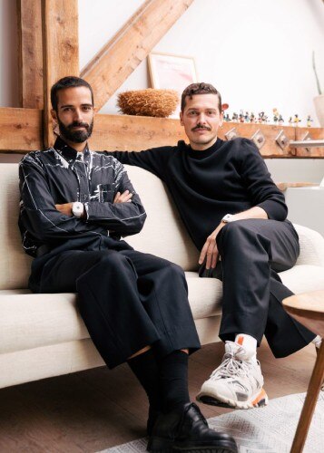 Andrea Trimarchi and Simone Farresin pose for a photo in a living room.