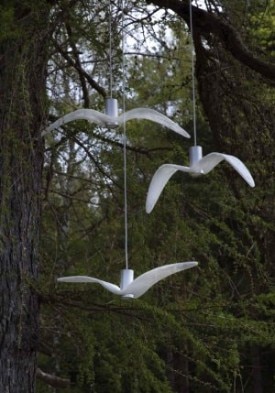 All three variants from Boris Klimek's Night Birds collection in white hang amidst some deciduous trees.