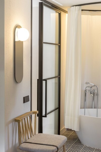 The medium-sized Circ A-3703-W wall mirror light from Estiluz illuminates a modern bathroom.