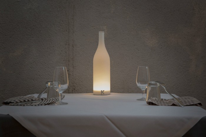 Bacco table light from Karman illuminates a rustic table for two.