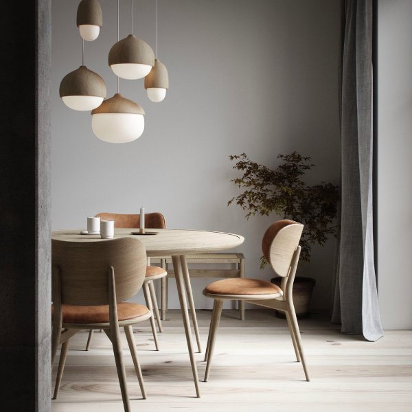 A cluster of Terho pendant lights from Mater hang above a sleek mid-century modern dining room.