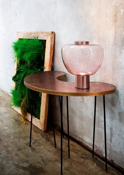 Vistosi's Riflesso LT3 table lamp, designed by Chiaramonte & Marin, sits in a rustic garden.