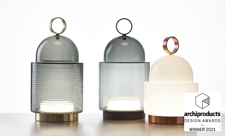 A trio of Brokis' Dome Nomad portable table lights by Chiaramonte Marin, with a range of sizes, finishes, and glass colour choices between them. The Archiproducts Winner badge appears in the lower right corner.