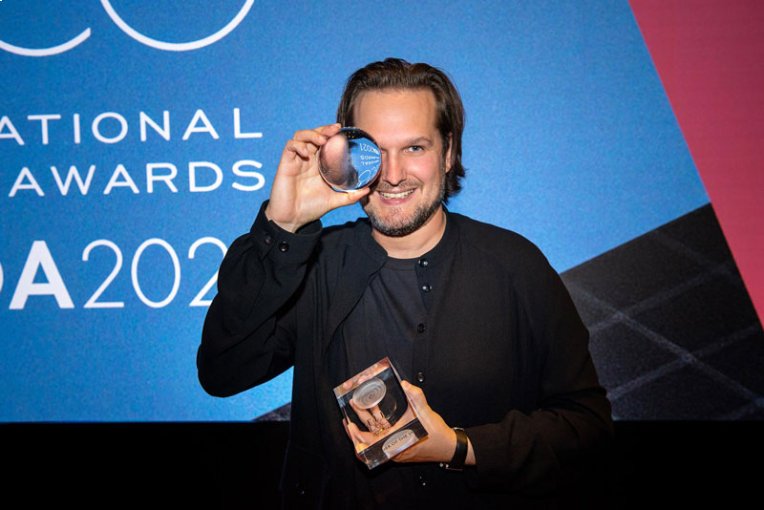 German lighting design genius Sebastian Herkner gleefully poses with his Designer of the Year Award on the red carpet at the Elle Deco International Design Awards ceremony.