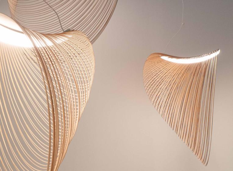 A close up of clustered Illan pendants, emphasizing the narrowness of the laser cut plywood line.