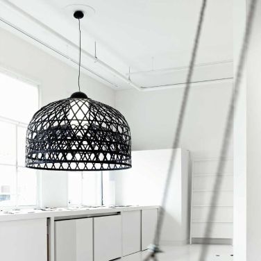 A clean white kitchen enjoys the contrast of Neri&Hu's Emperor suspension light for Moooi in black.