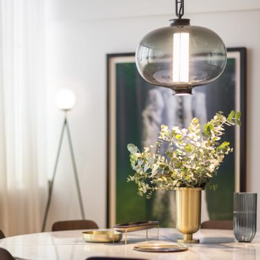 Parachilna's Bai T Ma Ma suspension light by Neri&Hu hangs above the centrepiece of a tastefully luxurious dining table in a bright and spacious dining room.