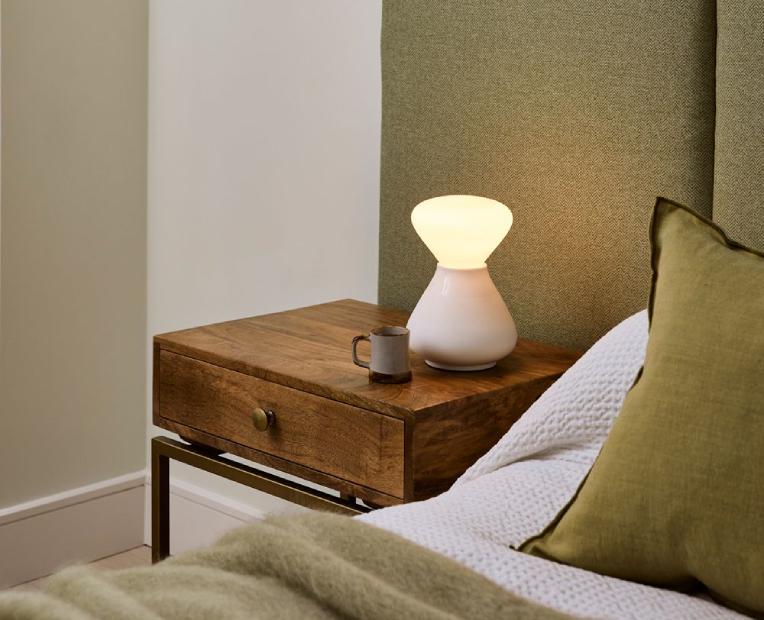 Noma table lamp from David Weeks' Reflection collection of lights for Tala illuminates a bedside table.