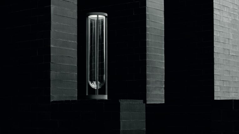 A dramatic image evocative of German Expressionist cinema, featuring In Vitro Bollard outdoor floor light, designed for Flos by legendary lighting designer Philippe Starck