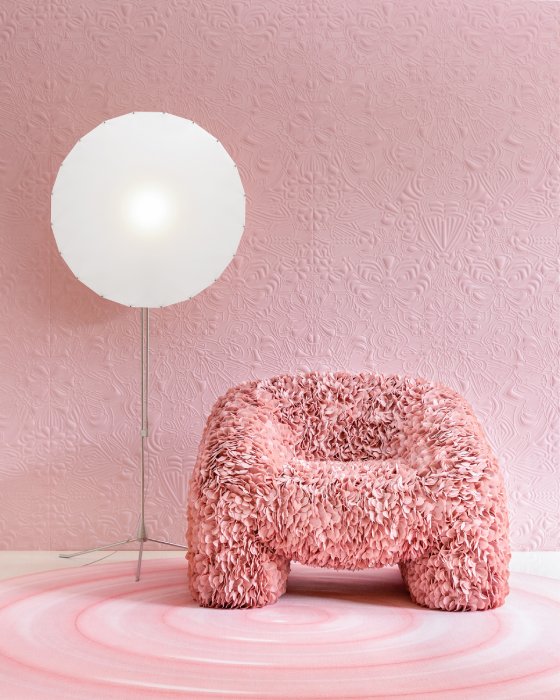 Lighting designer Rick Tegelaar's Filigree floor light for Moooi stands against a pink Rococo-textured background, next to a designer chair covered in a fabric that resembles a canopy of pink flowerpetals.