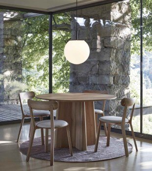 Sfera pendant light hangs above a wooden table in a dining nook.