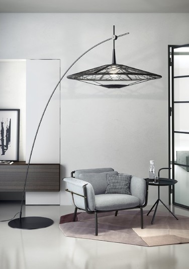 Forestier's Carpa floor light hangs its head over an easy chair in a muted contemporary living room.