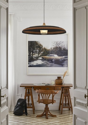 Jette Scheib's Grass suspension light from Forestier hangs above a wooden desk at the end of a hall.