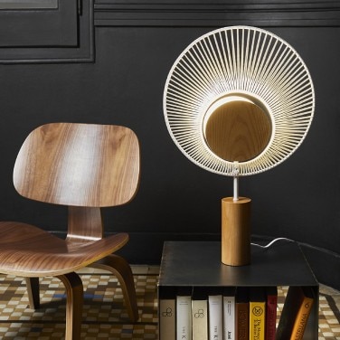 Oyster table light, designed for Forestier by Jette Scheib, sits on a side table next to a wooden chair.