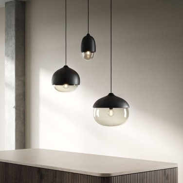 The Terho family of lights in black with transparent glass hangs above a kitchen island.