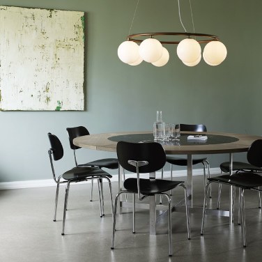 Miira 8 circular chandelier hangs above a small circular dining room table in a cozy Scandinavian apartment.