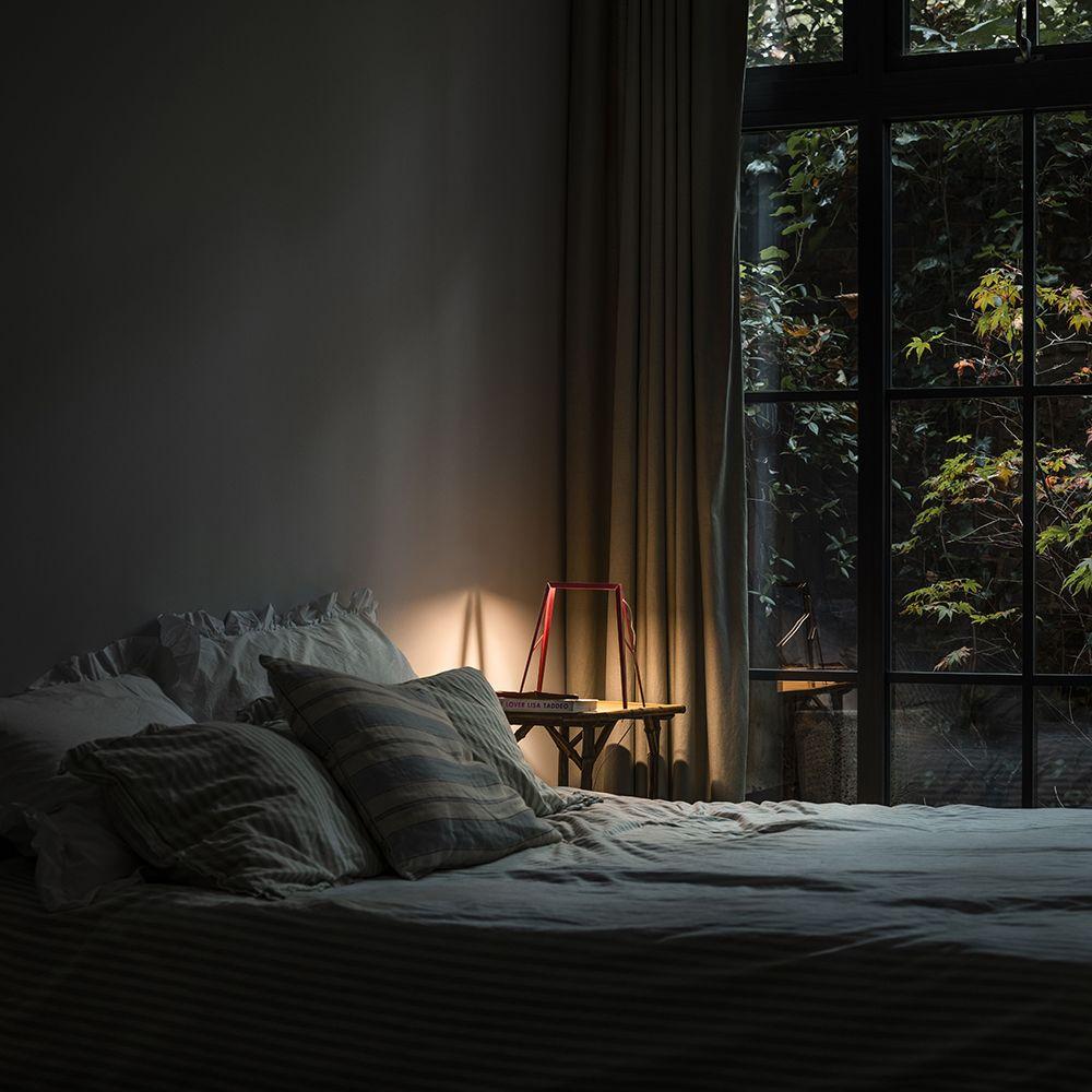 The Bridge in dark red placed upon a bedside table