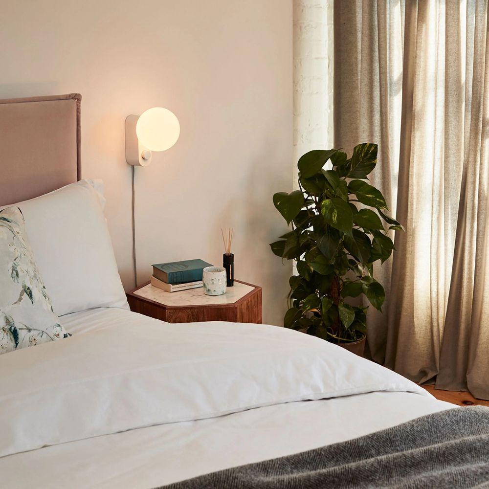 From left: Plug-in lights like the Alumina Wall from Tala and the Rise Wall from Normann Copenhagen are great solutions for adding layered lighting in bedrooms.