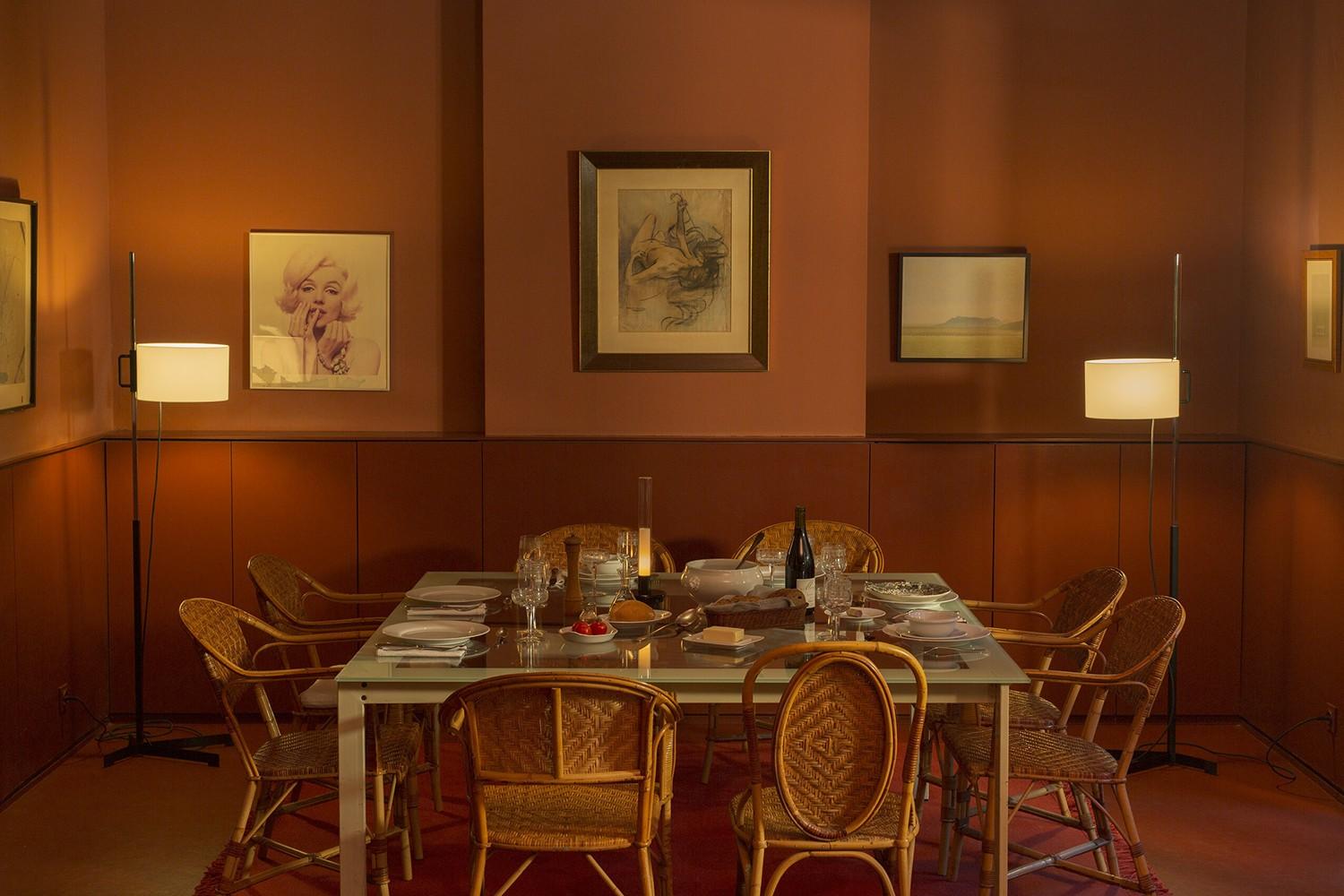 Two adjustable TMC Floor Lamps from Santa & Cole on either side of a dining table give the room a warm and inviting feel. The Sylvestrina Portable Lamp, also by Santa & Cole, placed in the middle of the table gives the diners a nice candle-like touch.