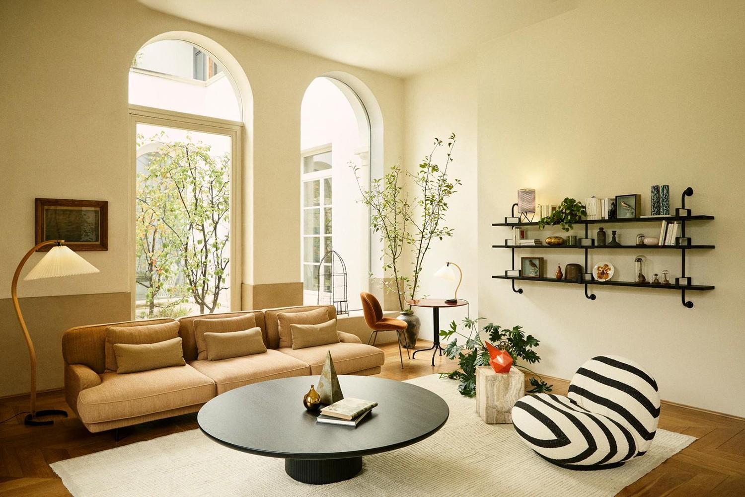 This luxurious living space is lit primarily with Gubi. From left to right: Timberline Floor Lamp next to the sofa, Timberline Table Lamp on the desk, and Bagdad Portable Lamp on the side table