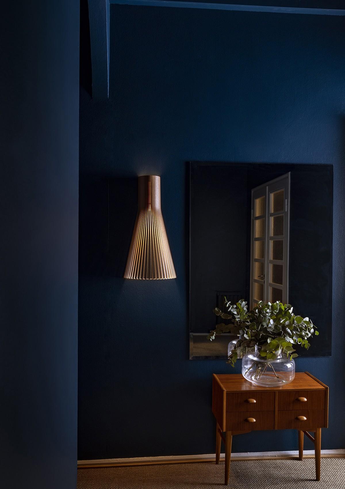 This Secto Wall Light adds texture and interest in this dark blue hallway. All wood from Secto is handmade of PEFC-certified form-pressed birch in Finland by highly skilled craftsmen.