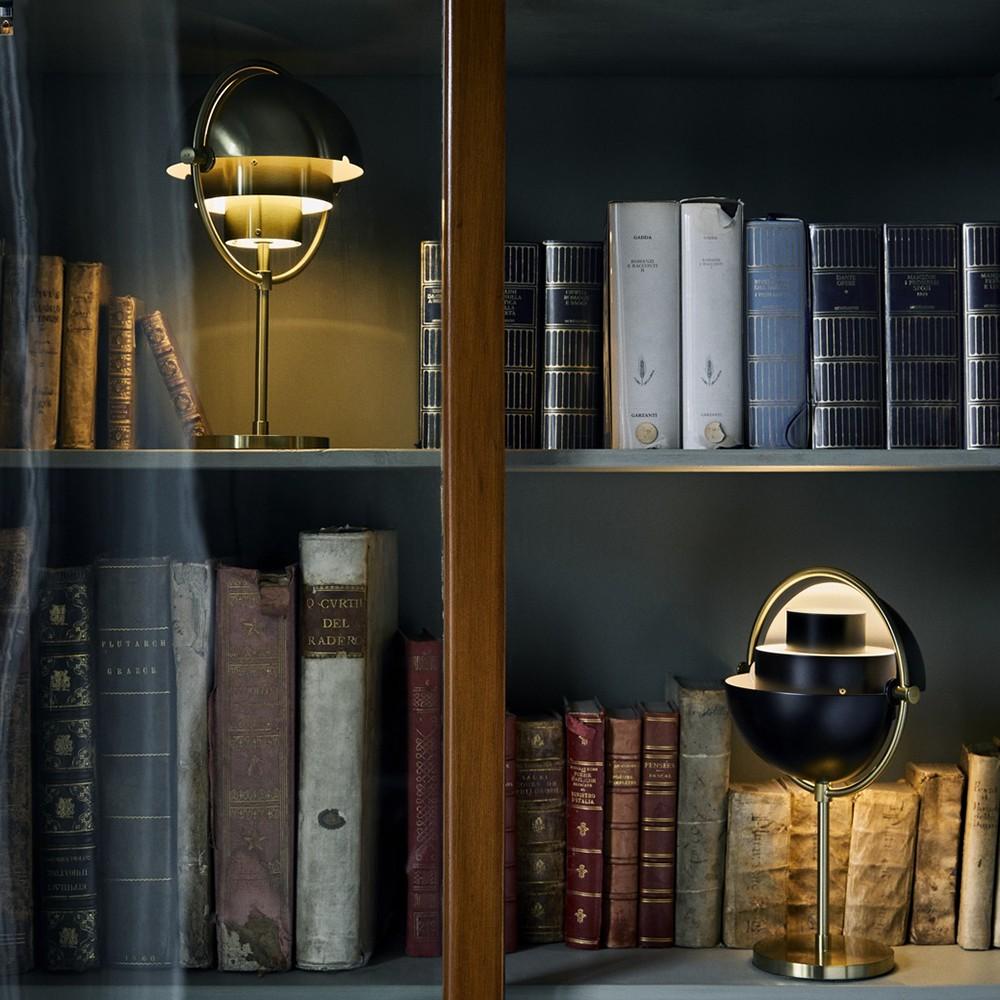 Two Multi-Lite Portable Lamps from Gubi in different colour ways light up special collections of rare books displayed on a bookcase.