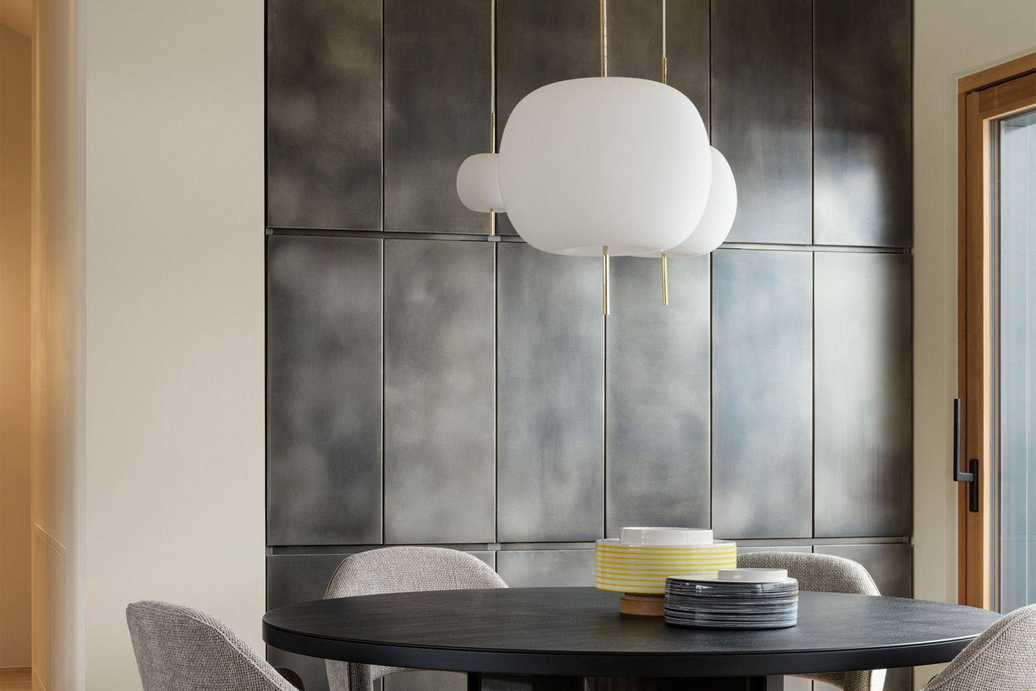 Varying sizes of the Kushi Pendants in a cluster over a dining area in a residence